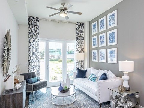 a living room with a white couch and a ceiling fan